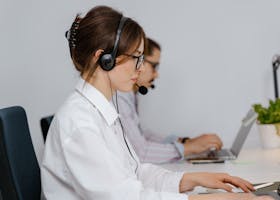 Customer service agents working at call center with headsets, focused on providing support.