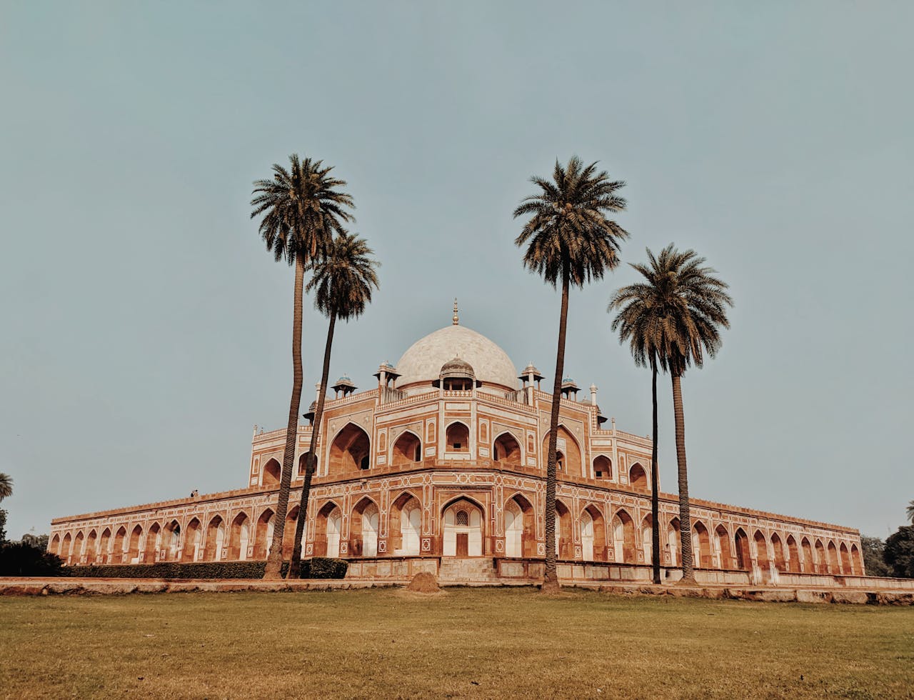 Captured view of Humayun's Tomb in New Delhi, framed by palm trees, a UNESCO World Heritage Site.