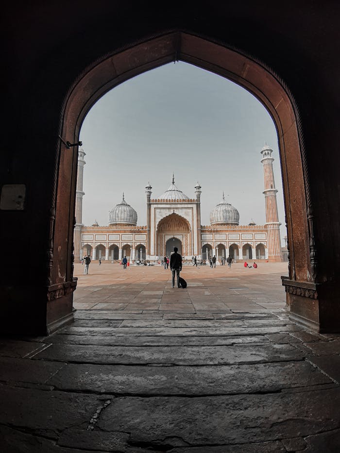 A stunning view of Jama Masjid Mosque in Delhi captured through an arched doorway.